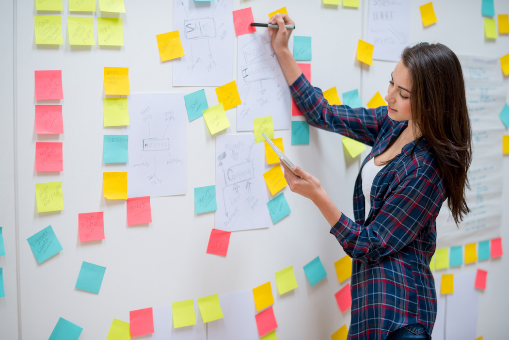 Planning out a keynote speech takes time — image of a presenter planning out a speech with post-it notes.