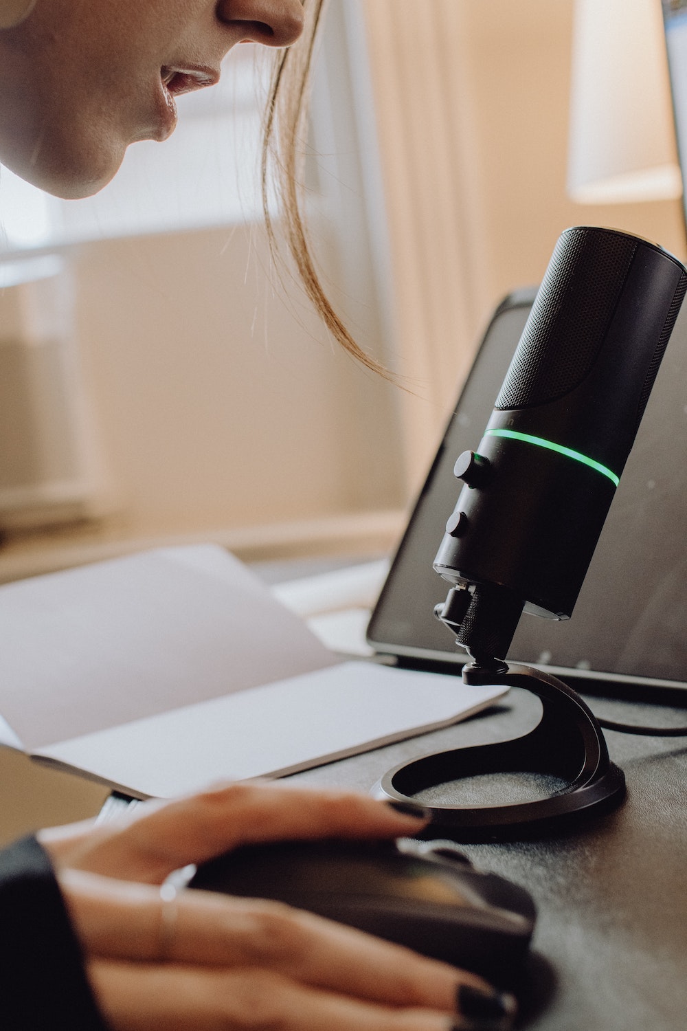 Woman speaking into a microphone, getting feedback for her speech through an online speech coach.