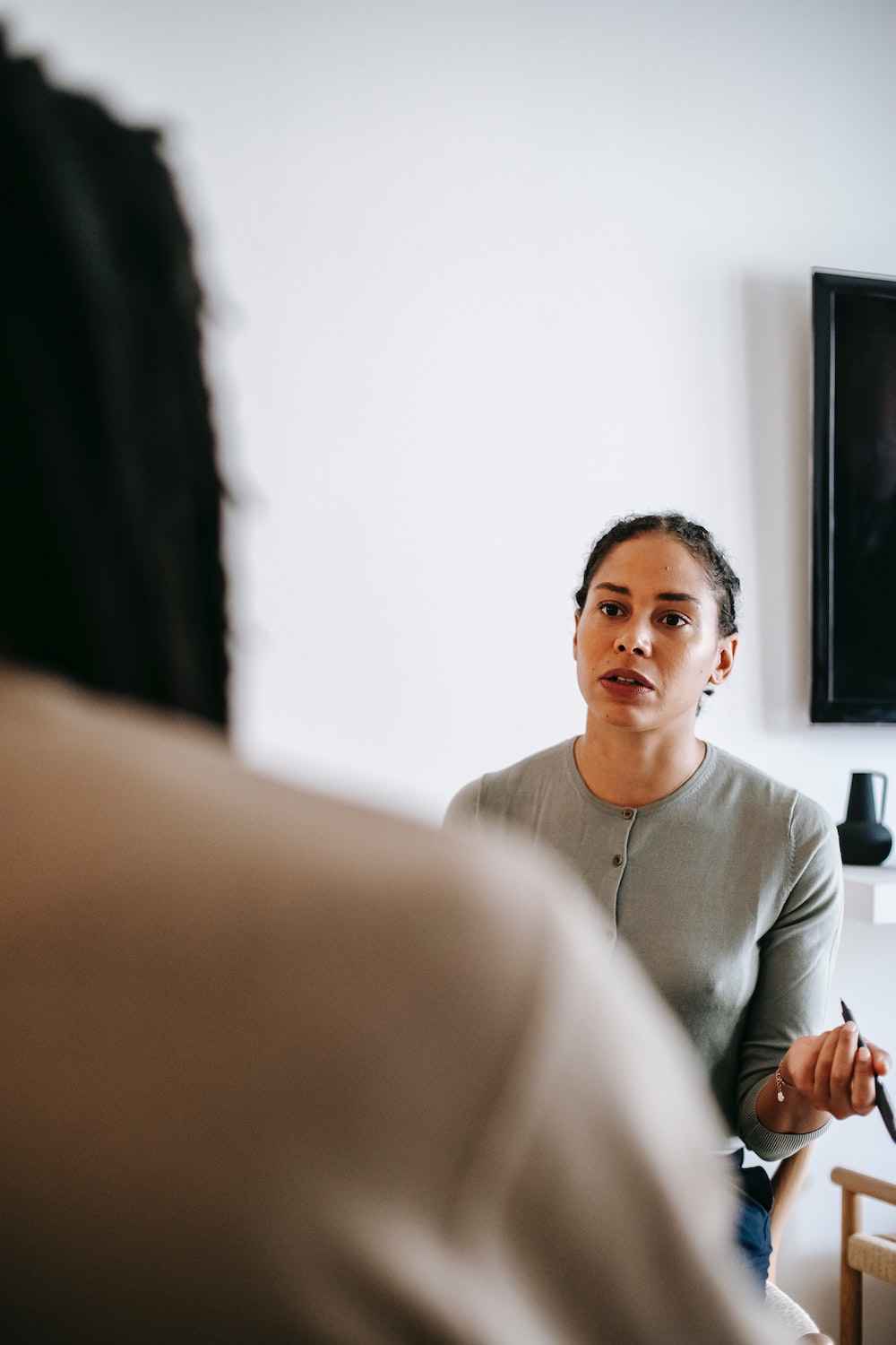 Woman speaking to a colleague looking distressed,  which often prompts people to overuse vocal fillers.