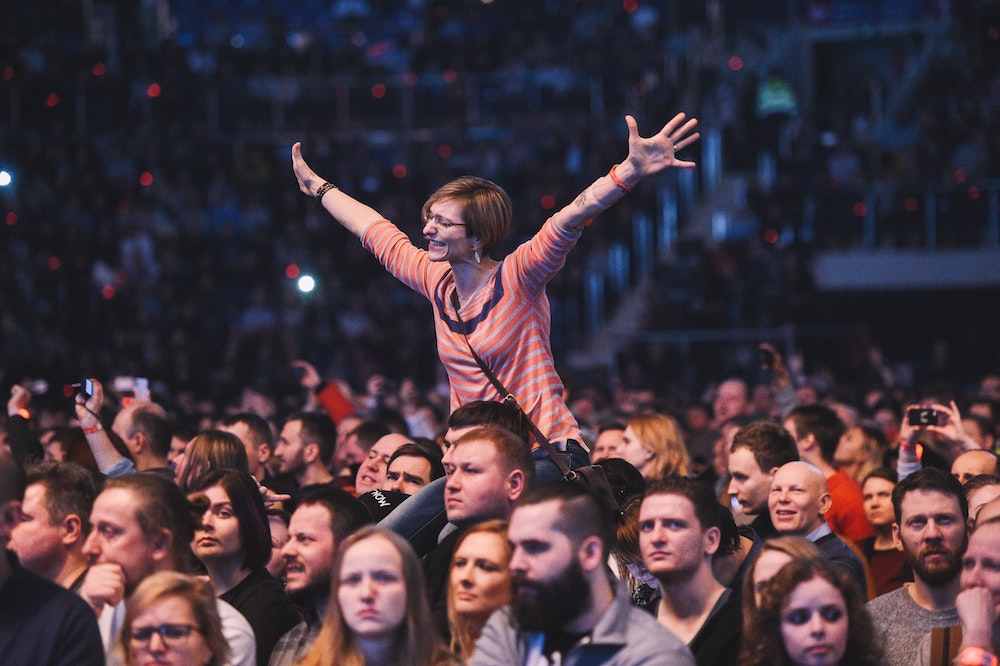 audience member with hands in the air, clearly being influenced by the message being expressed