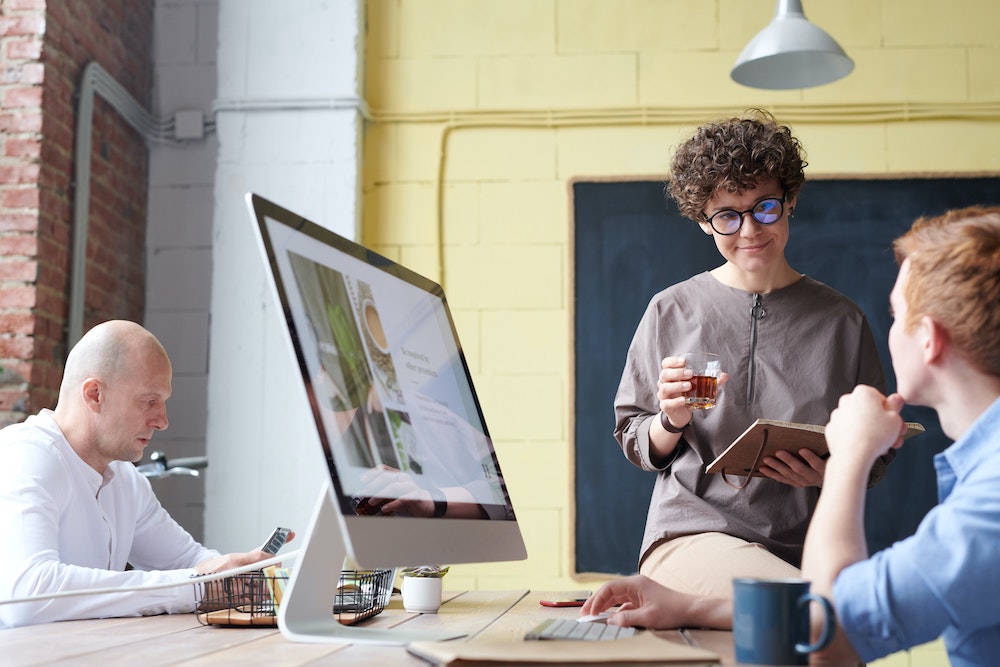 Woman with executive presence, talking to a team member.