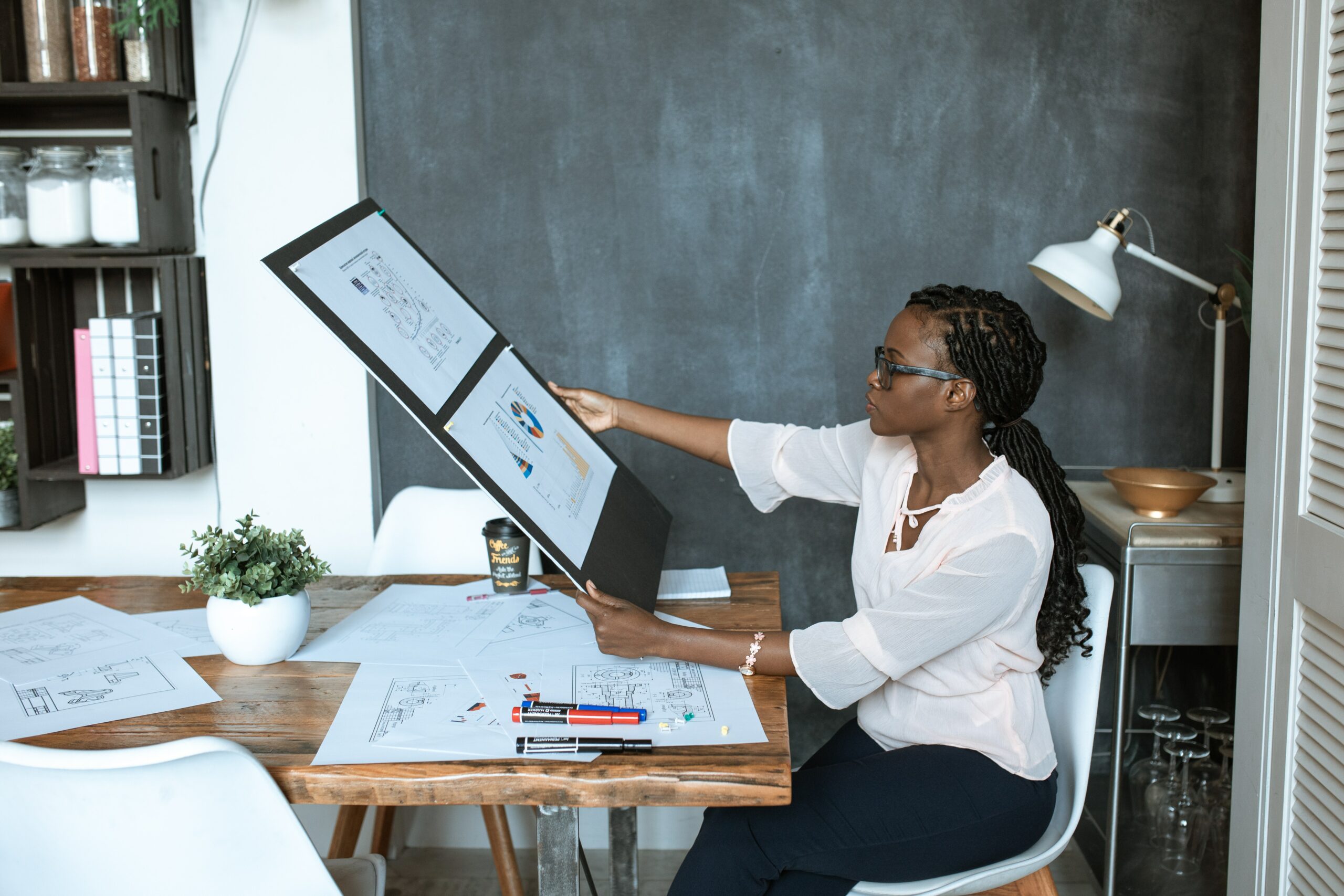 Woman sitting at a desk reviewing artwork which tells a story in a visual way