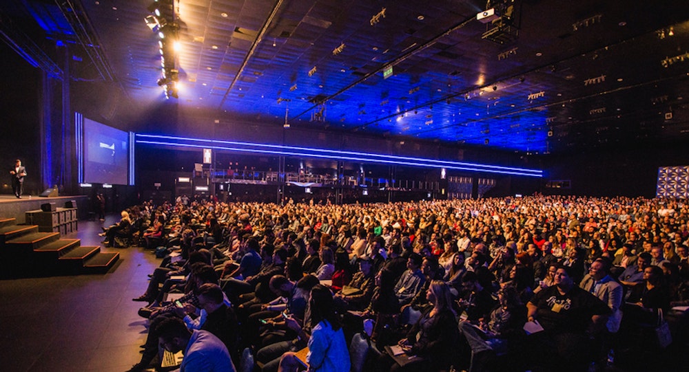 Man getting up on stage about to introduce himself for a presentation—and how you introduce yourself is a key aspect pull in and engage your audience.